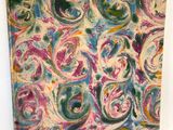 un gros plan d'une peinture sur une surface blanche, avec une étiquette