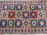 un tapis rouge, bleu et vert posé sur une surface blanche