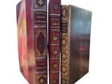 two old books sitting on top of each other on a white surface