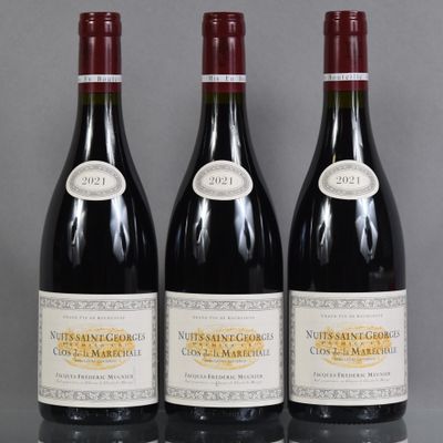 three bottles of red wine are lined up on a table