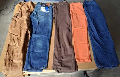 cinq paires de jeans disposées sur une table