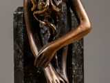 statue of a woman with her head in her hands on a book