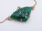 green jade and diamond pendant on gold chain on white surface