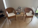 deux fauteuils en osier et une petite table dans une pièce
