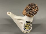 a white vase with a wooden handle holding a piece of wood