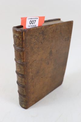 un livre marron sur lequel est accrochée une étiquette rouge