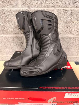 the motorcycle boots are on top of the box on the table