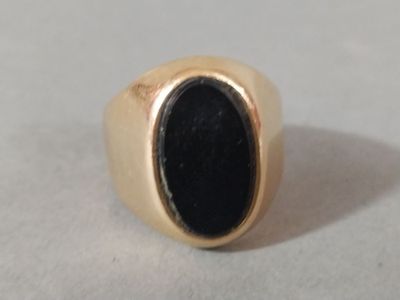 an image of a gold ring with a black stone in it