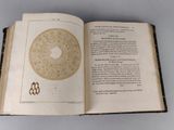 an open book with a picture of a circular design on it