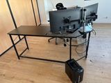 two computer monitors sitting on a desk in a room