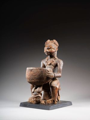 une image représentant une statue en bois d'un homme tenant un bol