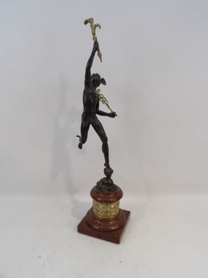 statue en bronze représentant un homme tenant une torche, posée sur un socle en bois