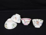 three small cups and saucers are sitting on a black surface