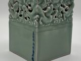 un vase vert orné d'un motif décoratif