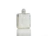 a small glass bottle with a lid on a white surface