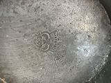a silver plate sitting on a table with a silver lid