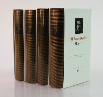 three books sitting on top of a white table next to each other