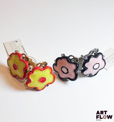 deux boucles d'oreilles posées sur une surface blanche