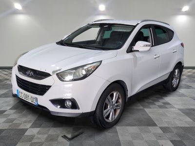 la voiture blanche est garée sur un sol en damier dans le garage