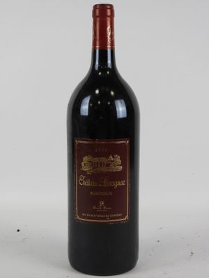 une vieille bouteille de vin rouge posée sur une table blanche