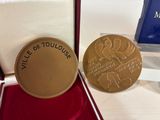an image of a gold medal in a box with a red velvet case