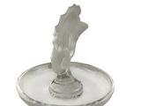 a glass candle holder with a statue of a hand on it