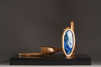 a close up of a sculpture of a pipe and a blue stone