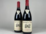 two bottles of red wine sitting next to each other on a table