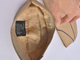 someone is holding a brown purse with a label on it