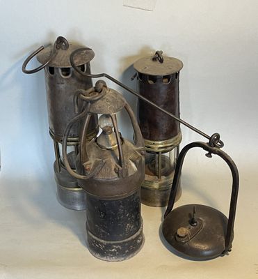 three different types of antique oil cans on a table