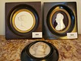 deux photos encadrées représentant un homme et une femme de profil, posées sur une table en marbre