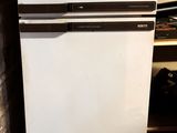 a white refrigerator in the corner of a room