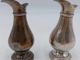 pair of antique silver plated vases on pedestal on white background