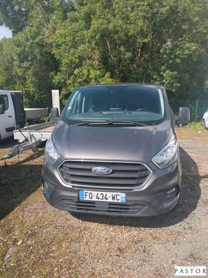a grey van parked next to a trailer in a parking lot
