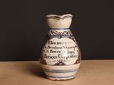 un vase blanc et bleu posé sur une table, sur fond noir