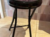a small stool with a painting on it in a bathroom