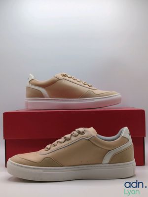 men ' s tan leather sneakers with white soles on top of a red box