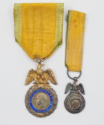 un gros plan sur deux médailles et une médaille posées sur une surface blanche