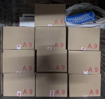 boxes stacked on top of each other in front of a brick wall