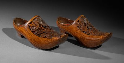 pair of wooden clogs with carved flowers and leaves