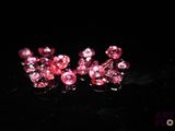 des perles de cristal roses sur une surface noire avec un fond noir