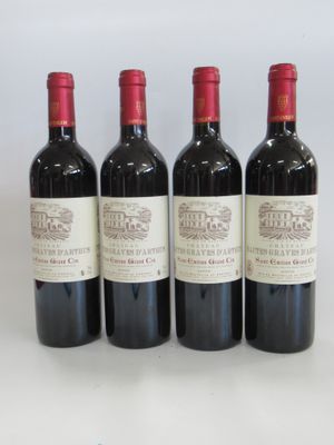 three bottles of red wine sitting next to each other on a table