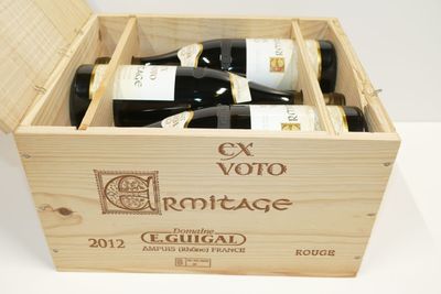 bouteilles de vin dans un coffret en bois sur une surface blanche