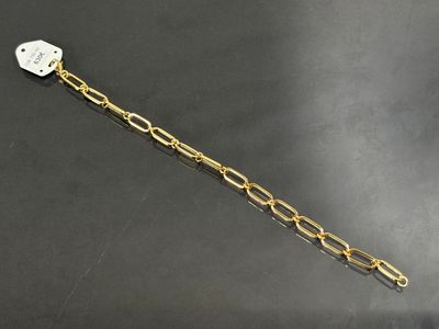 un gros plan sur un bracelet à chaîne en or orné d'un cœur blanc