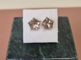 un gros plan sur une paire de boucles d'oreilles posées sur un bloc de marbre