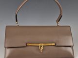 an image of a brown leather handbag with a gold handle