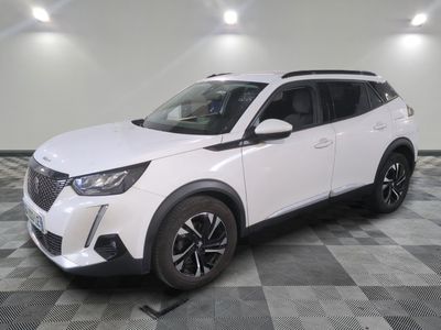 Le SUV blanc est garé dans une grande pièce au sol carrelé en damier.