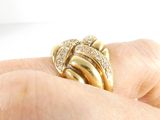 a person holding a gold ring with diamonds on it