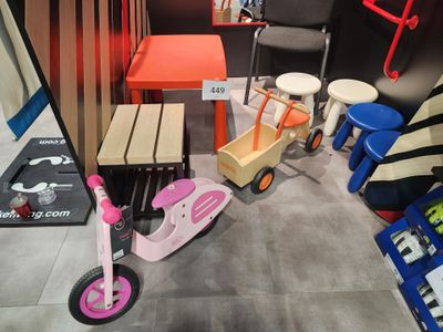 une petite table et des chaises dans une pièce où se trouve une trottinette rose
