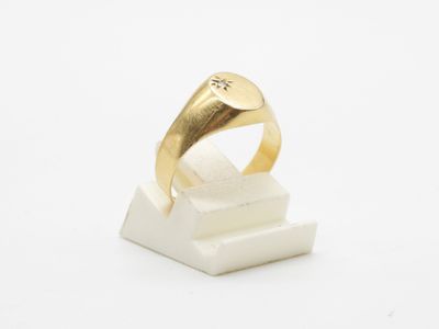 a close up of a gold ring on a white marble block